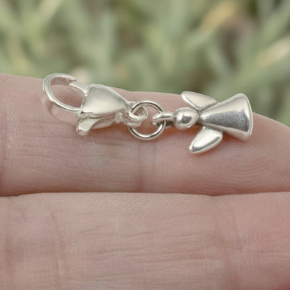 Hackberry Creek silver guardian angel charm with a stainless steel lobster clasp held on a person's finger