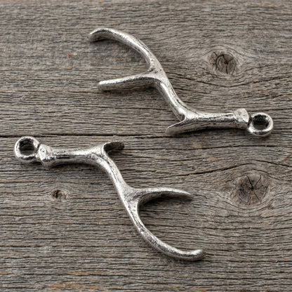 Hackberry Creek Nunn Design silver plated pewter antler charms for artisan jewelry making on a rustic wood background