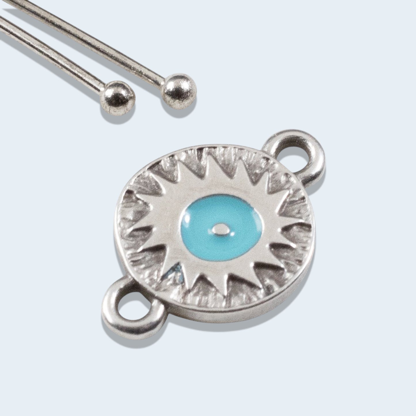 Hackberry Creek antique silver round evil eye connector charm with vibrant aqua enamel and starburst texture detail.