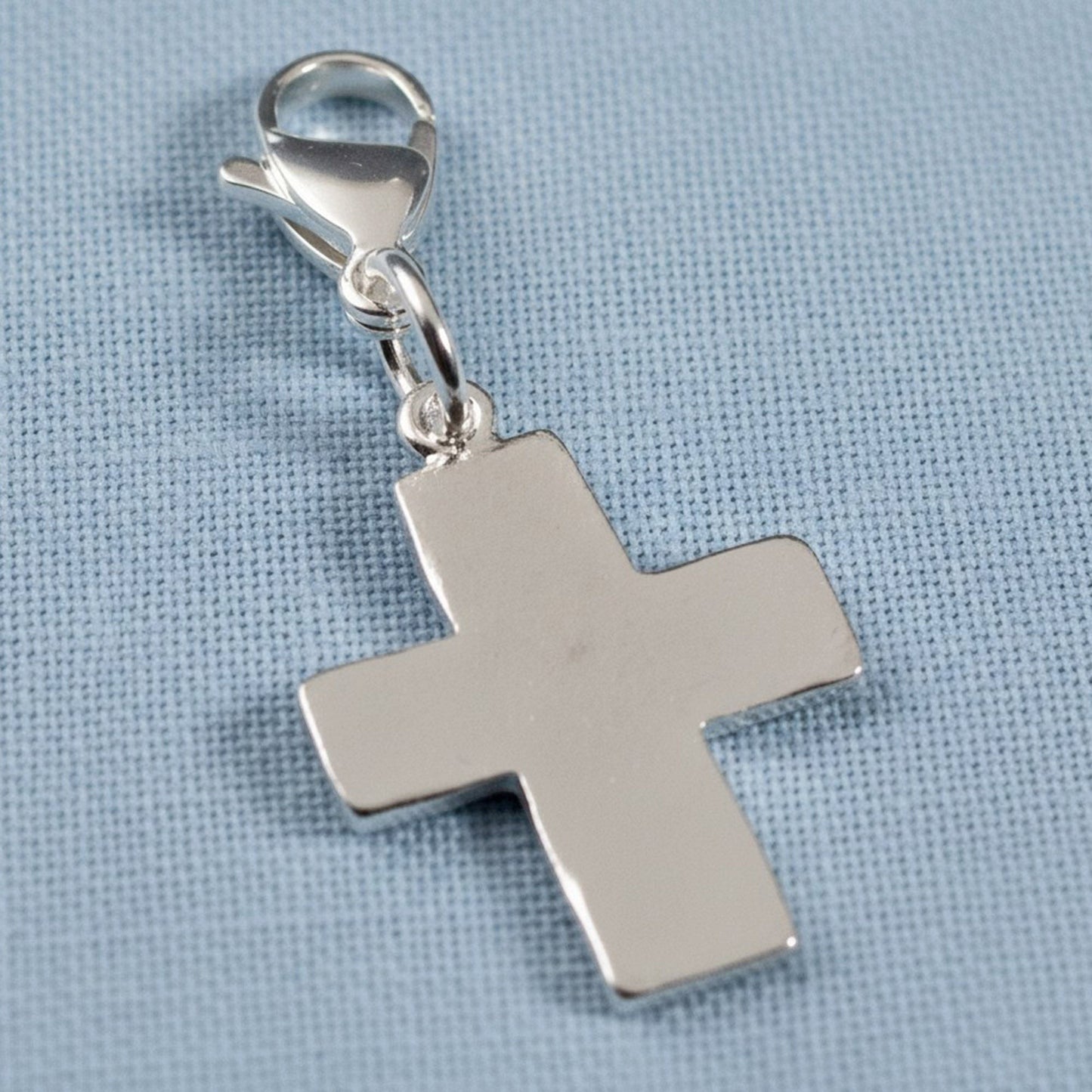 Hackberry Creek silver cross charm with a lobster clasp, featuring a distressed finish for bags or jewelry.