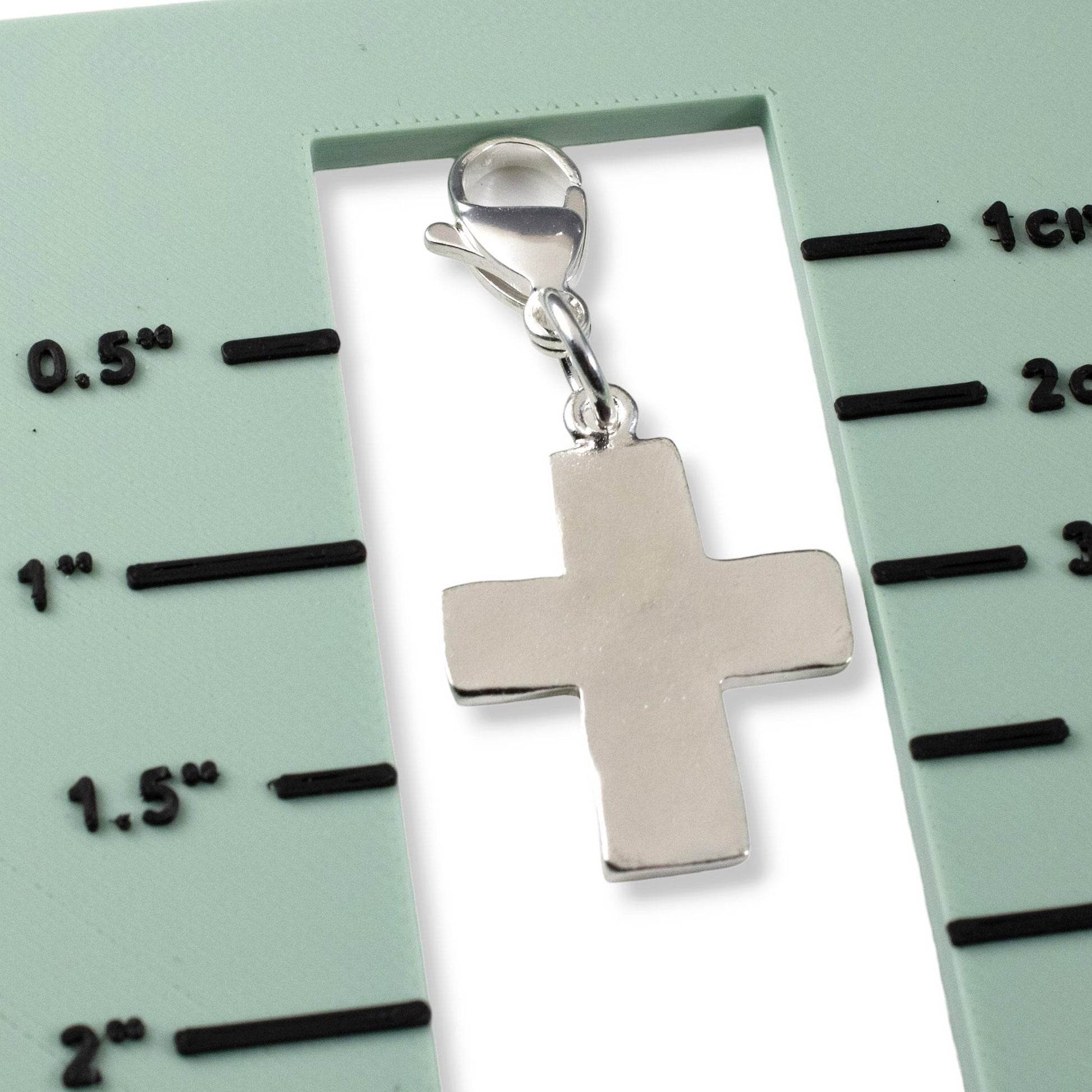 Hackberry Creek silver-plated pewter cross charm with lobster clasp for purses or jewelry, shown against a size guide.