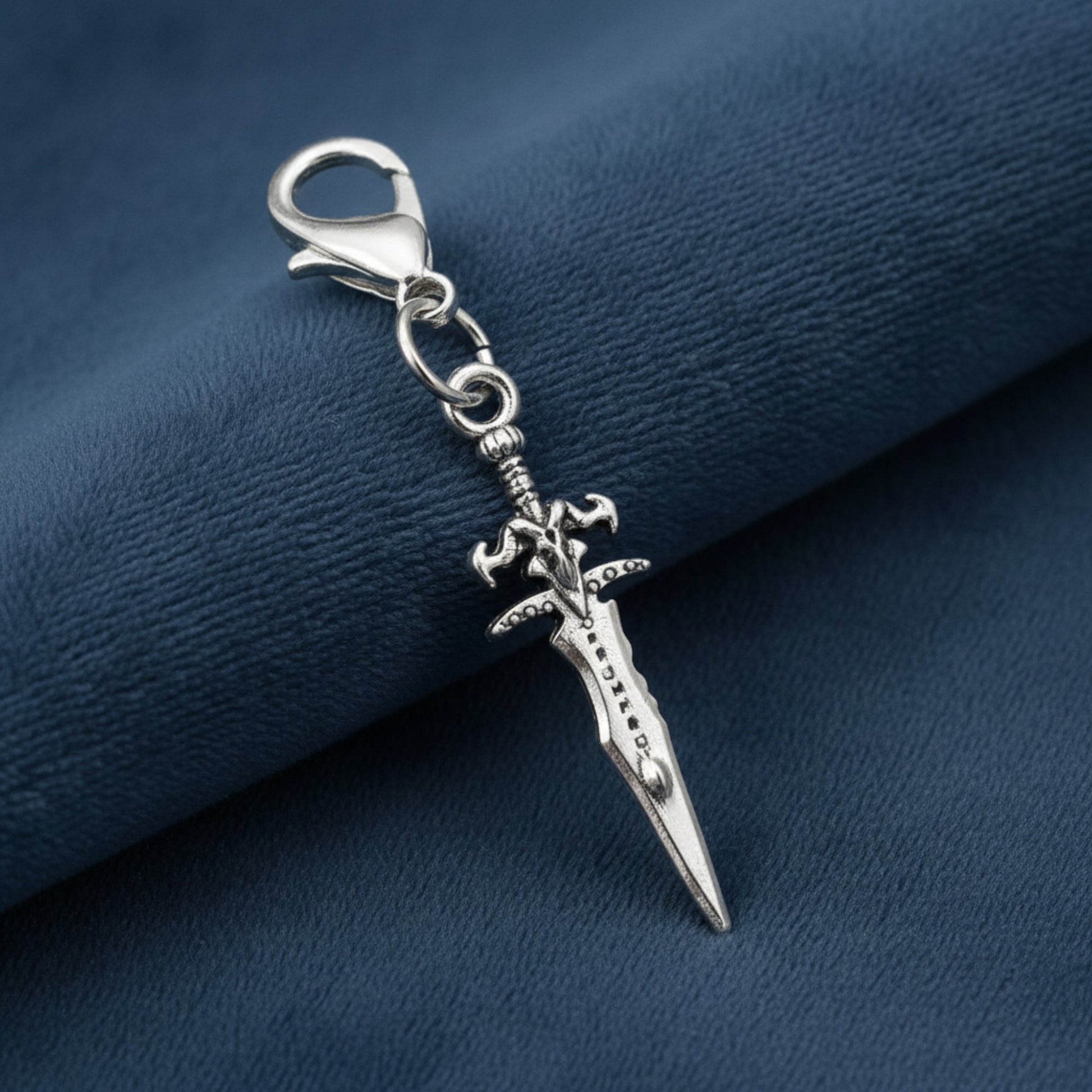 Hackberry Creek silver metal alloy dagger charm with intricate detailing and lobster clasp closure.