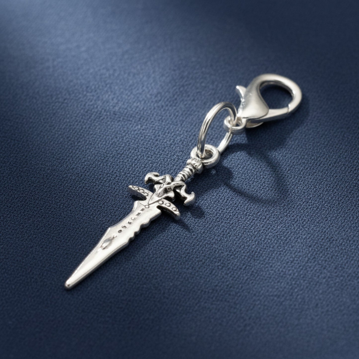 Hackberry Creek silver metal alloy dagger charm with lobster clasp, 1 3/4" long, double-sided medieval fantasy design.