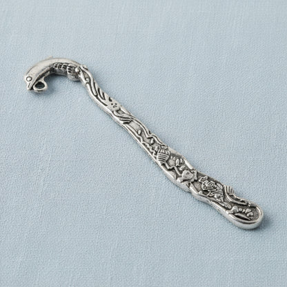 Hackberry Creek antique silver dolphin bookmark with beach-themed engraving and charm loop on a light blue background.