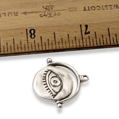 Hackberry Creek silver plated evil eye pendant with hand-formed texture shown next to a ruler for size reference.