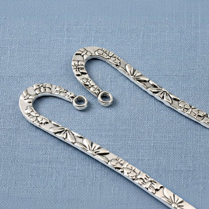 Hackberry Creek silver zinc alloy hook bookmarks with raised floral and butterfly patterns for DIY jewelry projects.