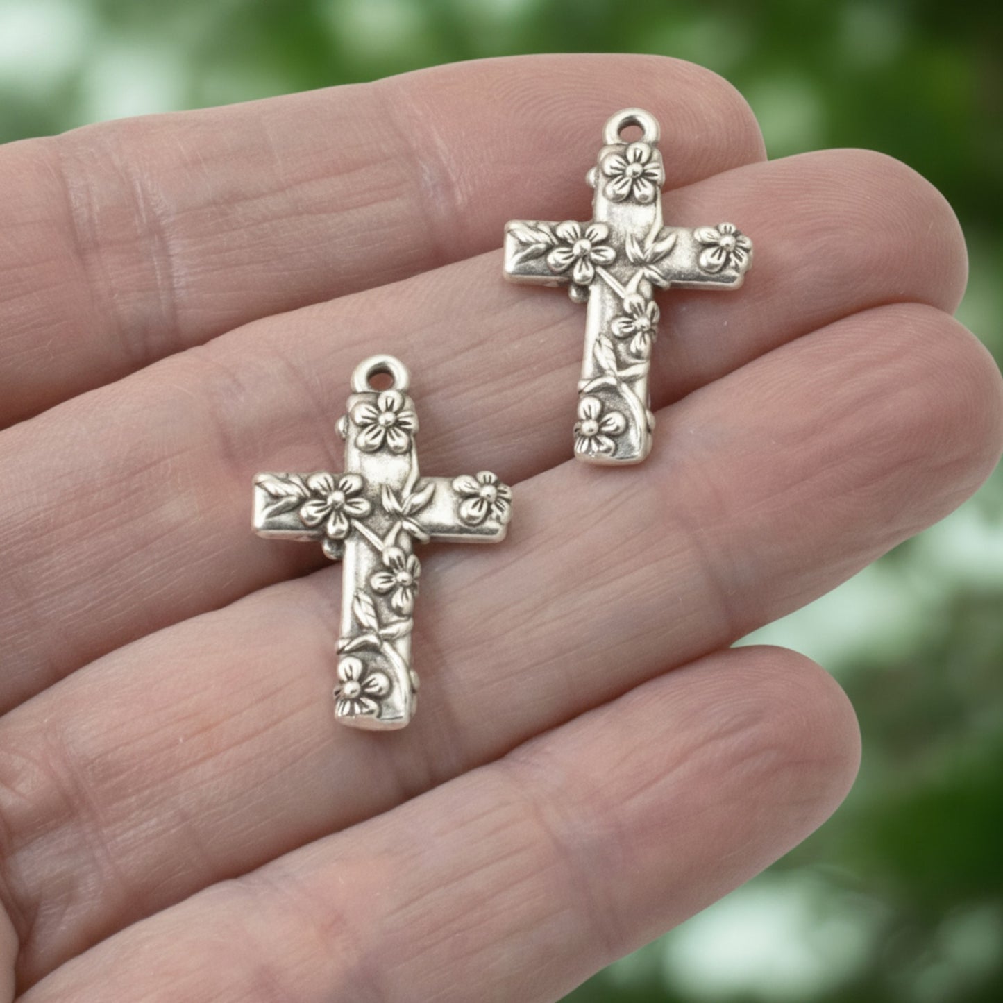 Hackberry Creek silver-plated pewter floral cross pendants with intricate raised flower details for religious jewelry.