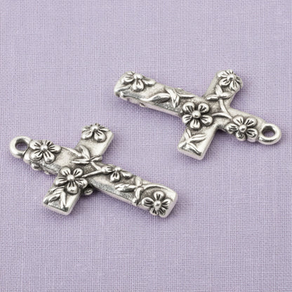 Hackberry Creek silver-plated pewter floral cross pendants with intricate raised flower details for jewelry making.