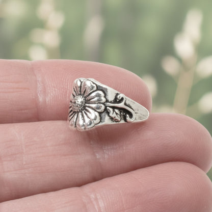 Hackberry Creek TierraCast silver pinch bail with antique floral and vine detail held between fingers