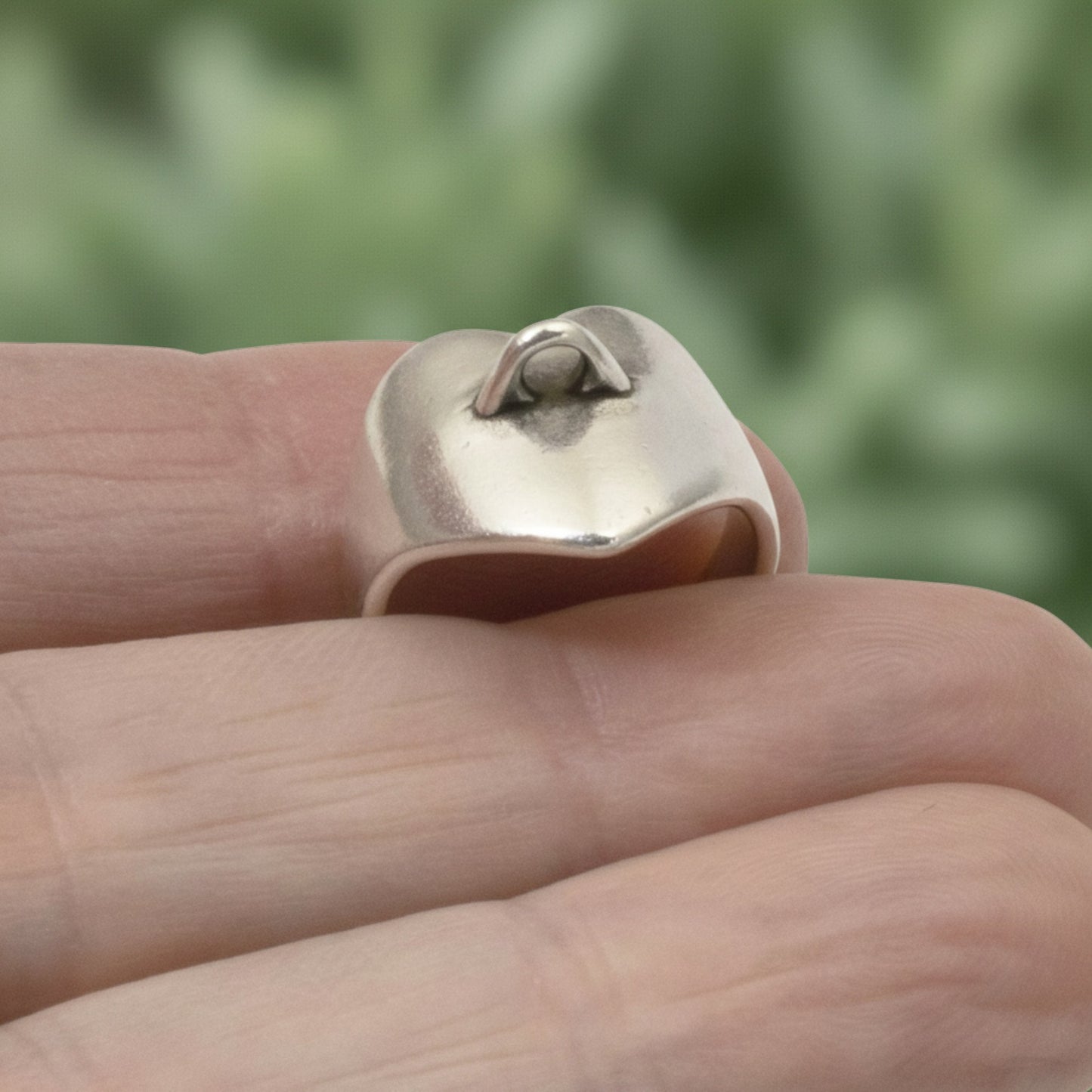 Hackberry Creek silver-plated heart ring base with a charm loop, held on a finger for DIY jewelry making.