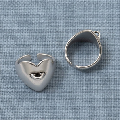Hackberry Creek set of two silver-plated heart-shaped adjustable ring bases with charm loops on a blue fabric background.