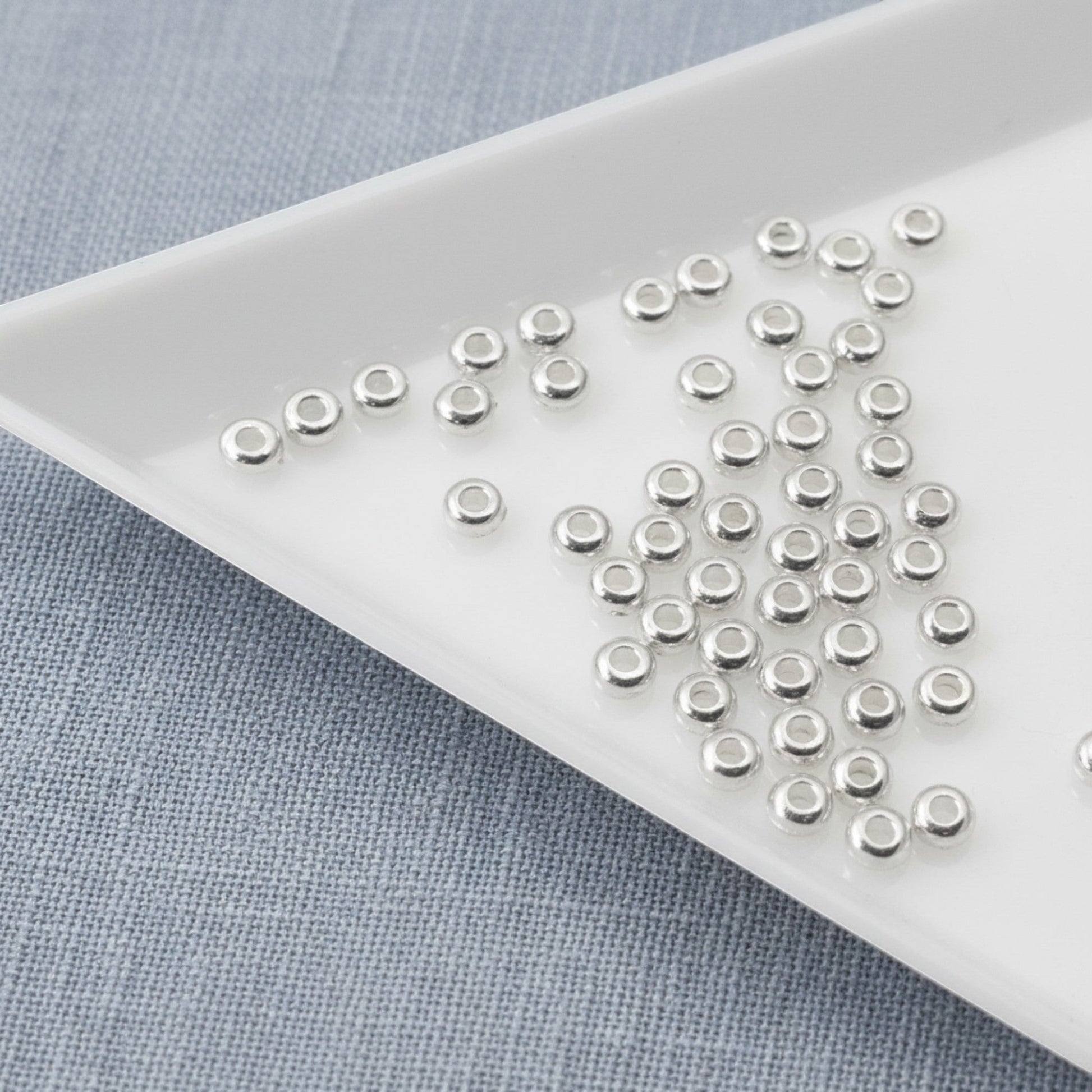 Hackberry Creek 3mm silver heishi disc spacer beads, made of .999-plated pewter, smooth and bright finish.