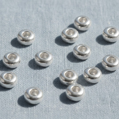 Hackberry Creek 3mm silver heishi disc spacer beads, made of .999-plated pewter, smooth finish.