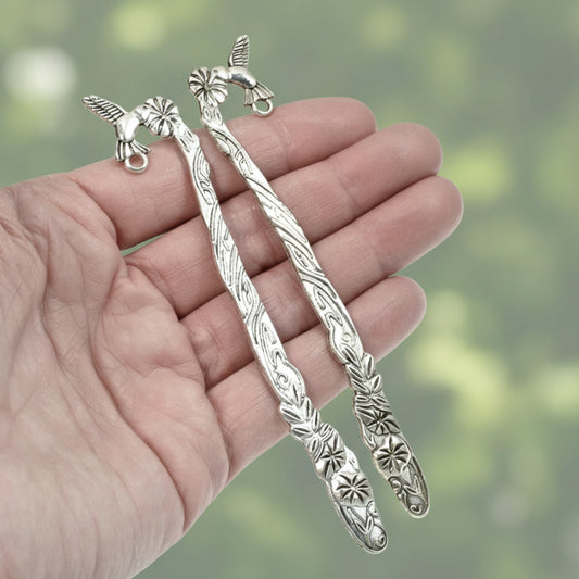Hackberry Creek antique silver metal bookmark blanks featuring hummingbird and flower designs held in a hand