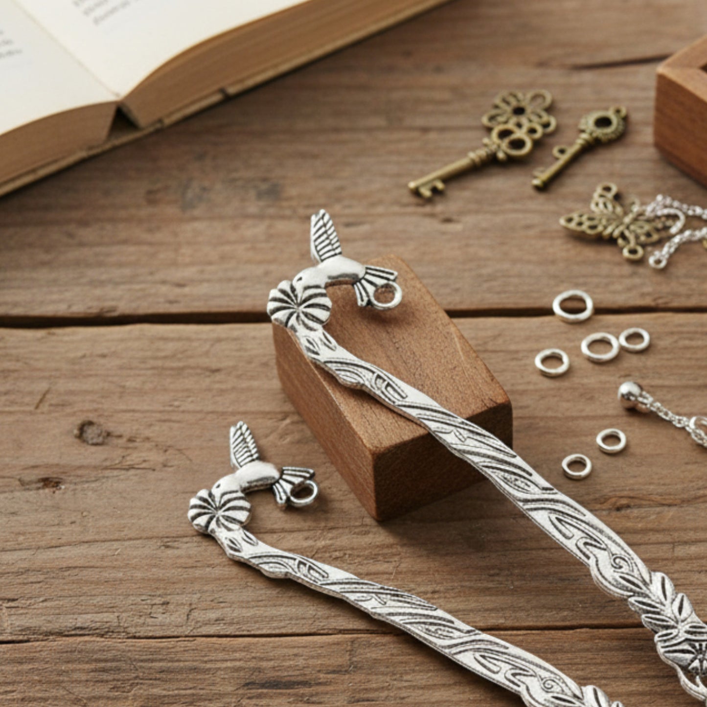 Hackberry Creek antique silver zinc alloy hummingbird and flower metal bookmark blanks on a wooden craft table