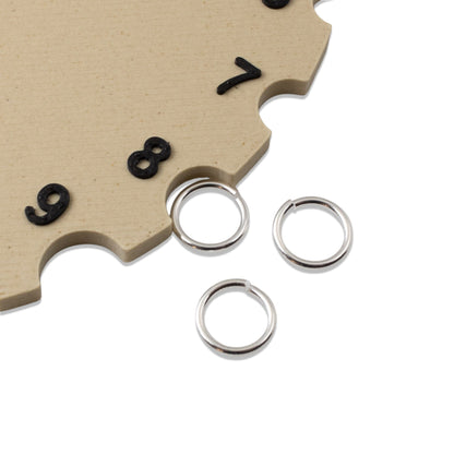 Hackberry Creek 8mm silver plated brass jump rings for jewelry making on a wooden clock face background