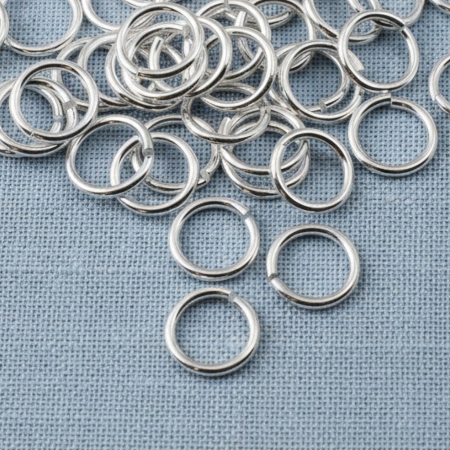 Hackberry Creek 8mm silver-plated brass jump rings for jewelry making, featuring a bright polished finish.