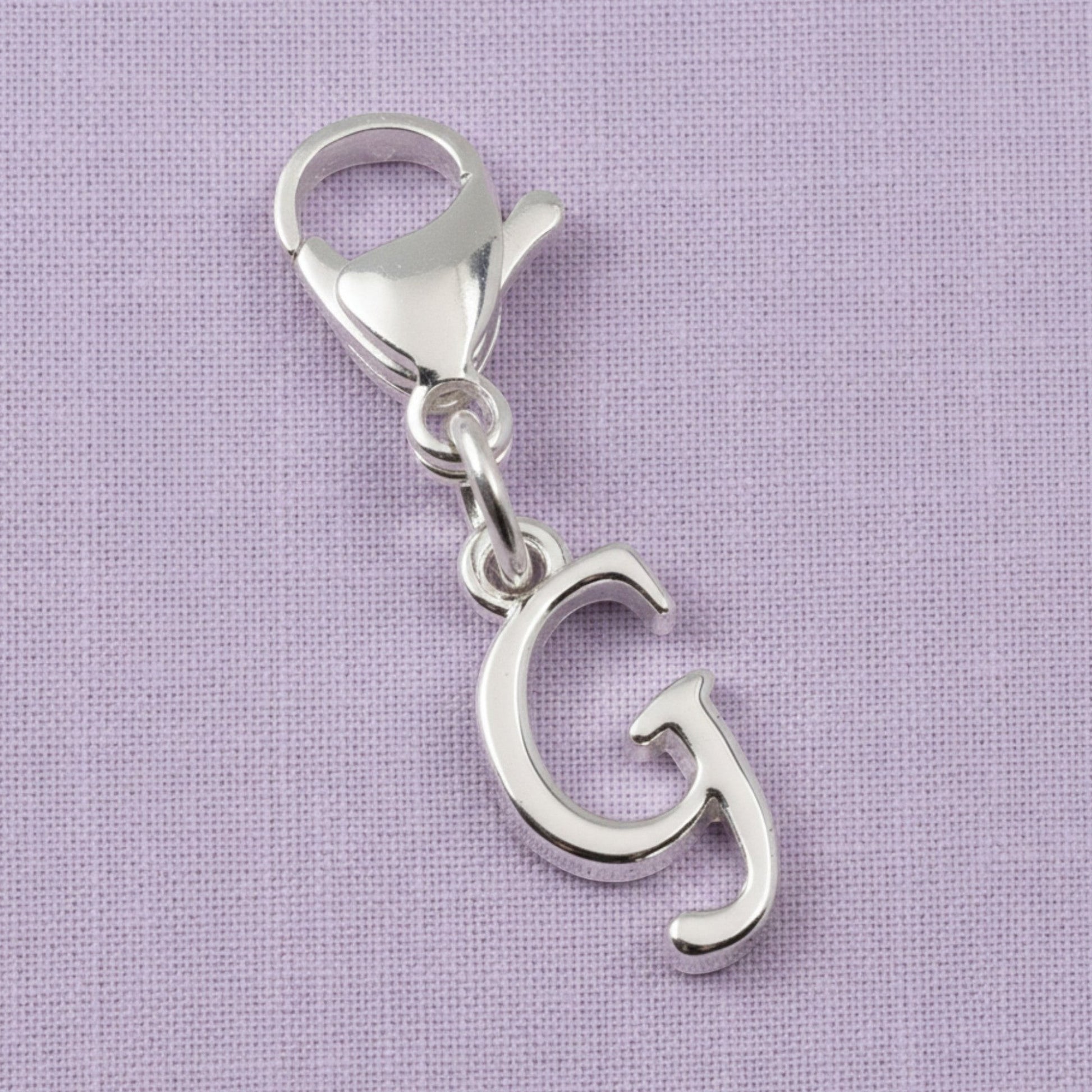 Hackberry Creek silver cursive letter G charm with a stainless steel lobster clasp for journals or bracelets.