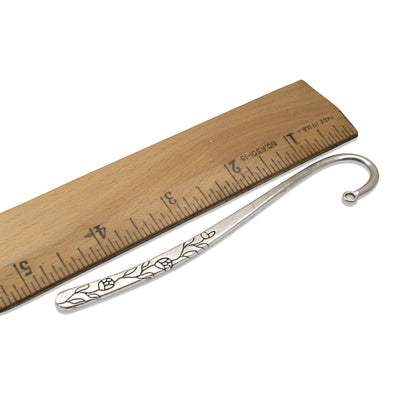 Hackberry Creek antique silver rose and vine metal bookmark base with shepherd hook next to a wooden ruler