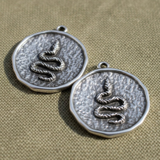 Hackberry Creek two silver-plated hammered coin pendants with a raised serpent relief design and antique finish.