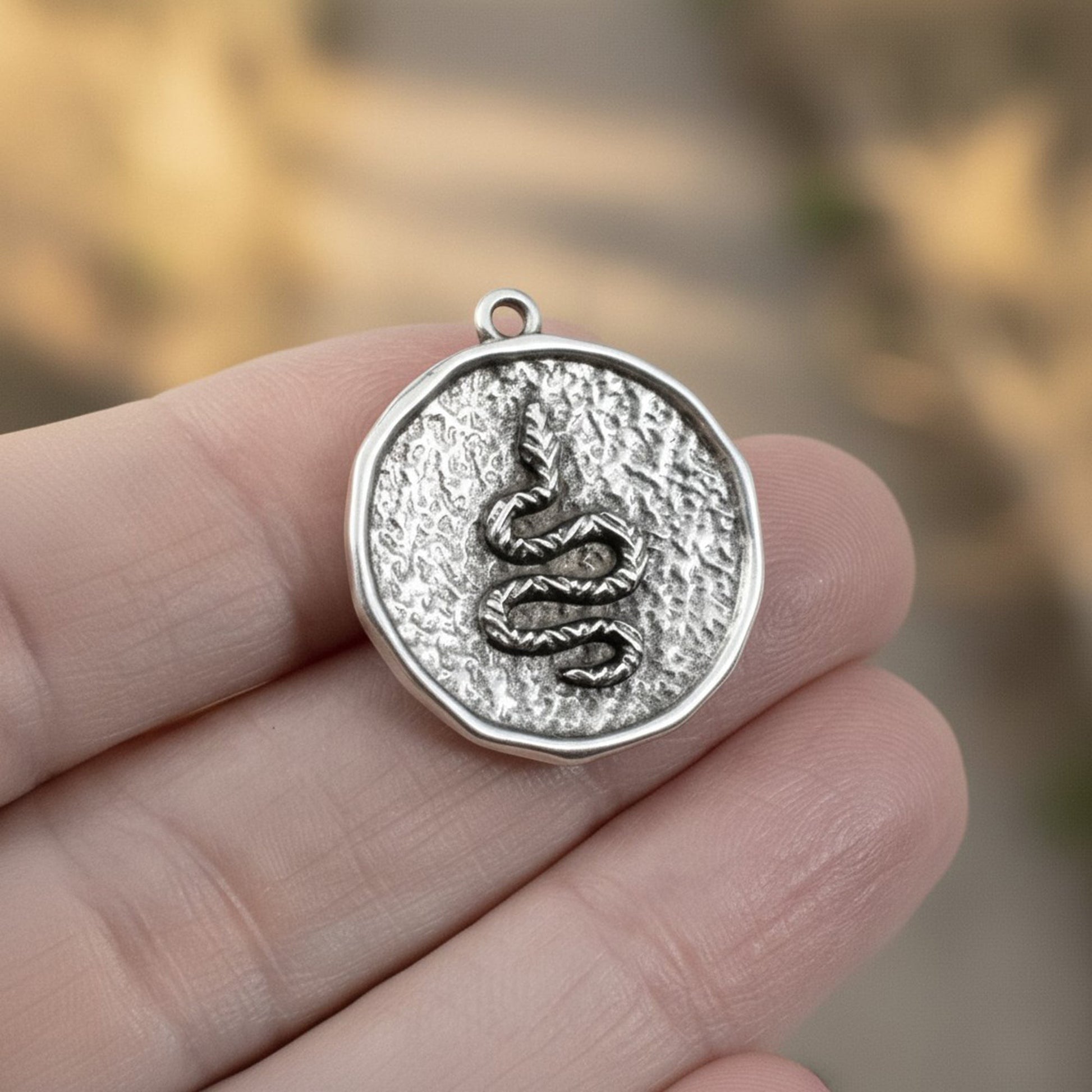 Hackberry Creek antique silver plated hammered coin pendant with raised serpent relief. Boho charm.