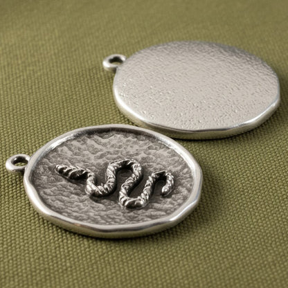 Hackberry Creek two silver plated hammered coin pendants with raised serpent relief and antique finish.