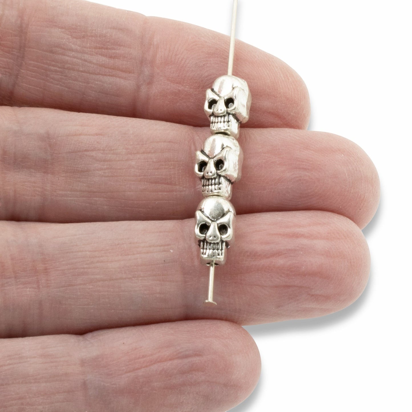 Hackberry Creek antique silver 3D skull alloy beads on a needle for jewelry making
