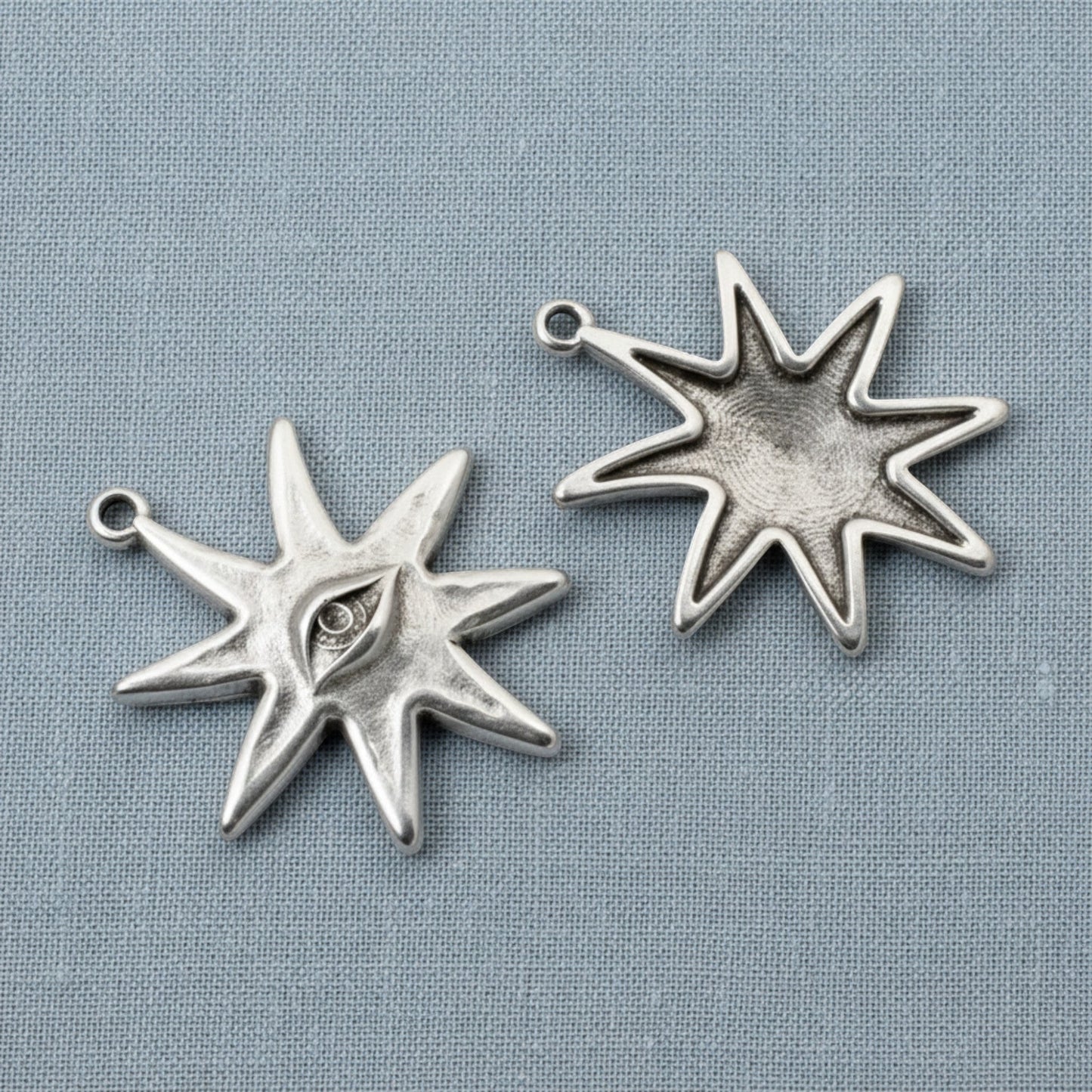 Hackberry Creek silver star eye pendants showing front and back views of the celestial jewelry charms.