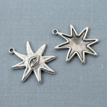 Hackberry Creek silver star eye pendants showing front and back views of the celestial jewelry charms.