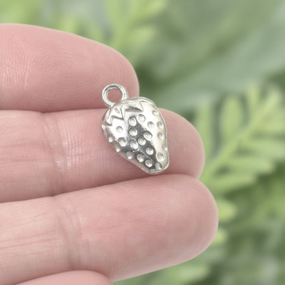 Hackberry Creek silver strawberry charm with textured surface and hanging loop. Zinc alloy, 10mm x 17mm.