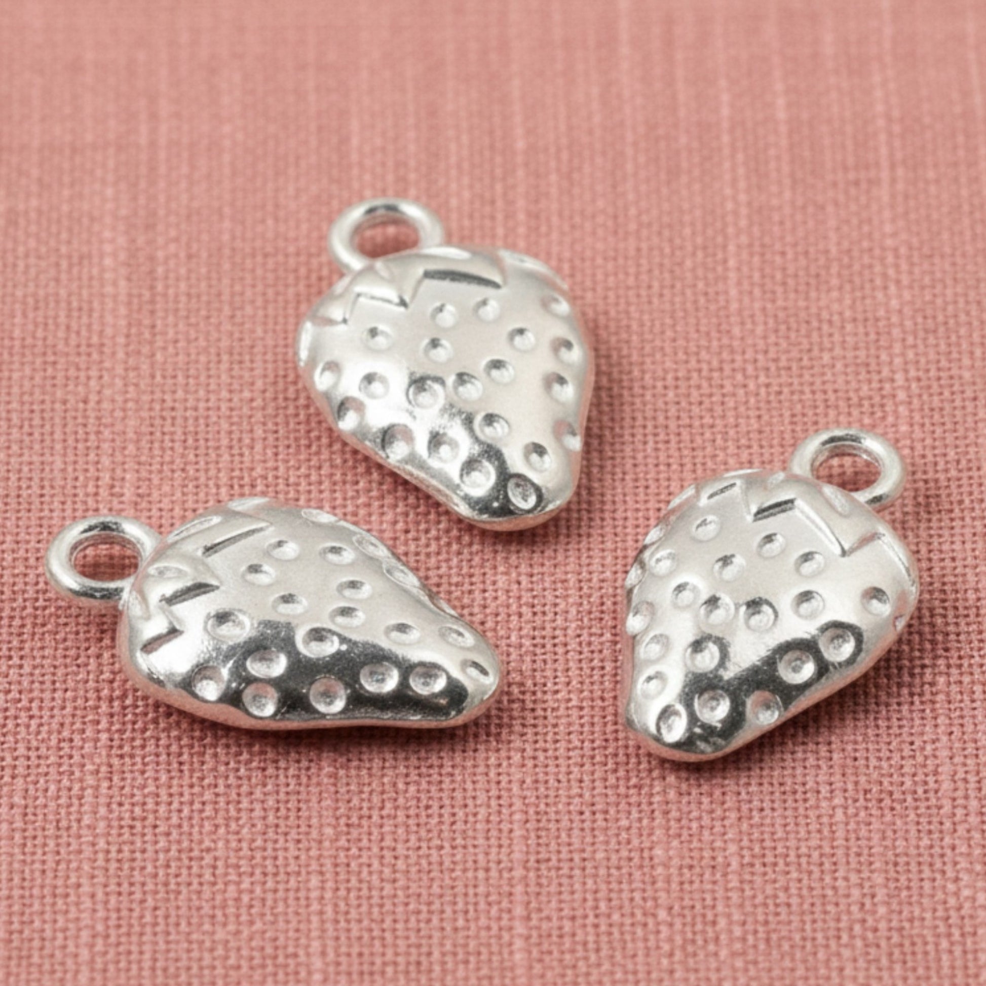 Hackberry Creek silver zinc alloy strawberry charms with textured detail and hanging loops, 10mm x 17mm.