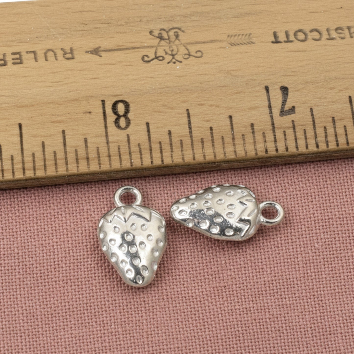 Hackberry Creek silver strawberry charms made of zinc alloy with a textured surface and a tarnish-resistant finish.