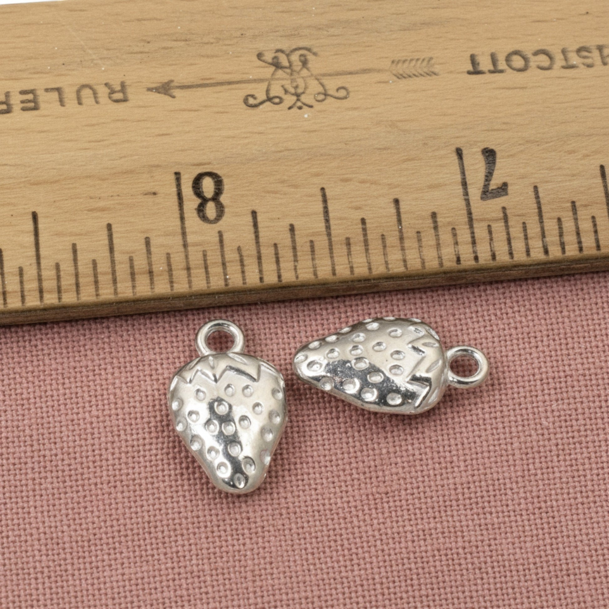 Hackberry Creek silver strawberry charms made of zinc alloy with a textured surface and a tarnish-resistant finish.