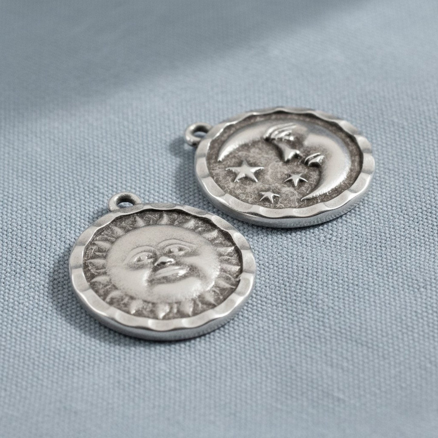Hackberry Creek antique silver double-sided celestial pendants featuring a sun face and a crescent moon with stars.