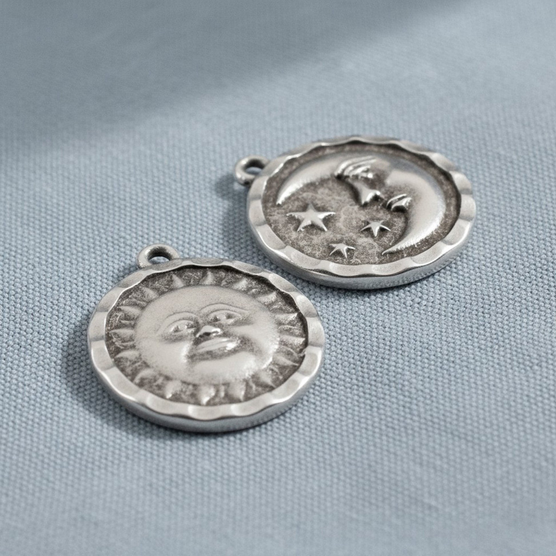 Hackberry Creek antique silver double-sided celestial pendants featuring a sun face and a crescent moon with stars.