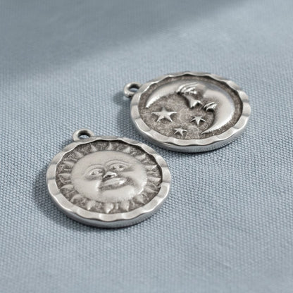 Hackberry Creek antique silver double-sided celestial pendants featuring a sun face and a crescent moon with stars.