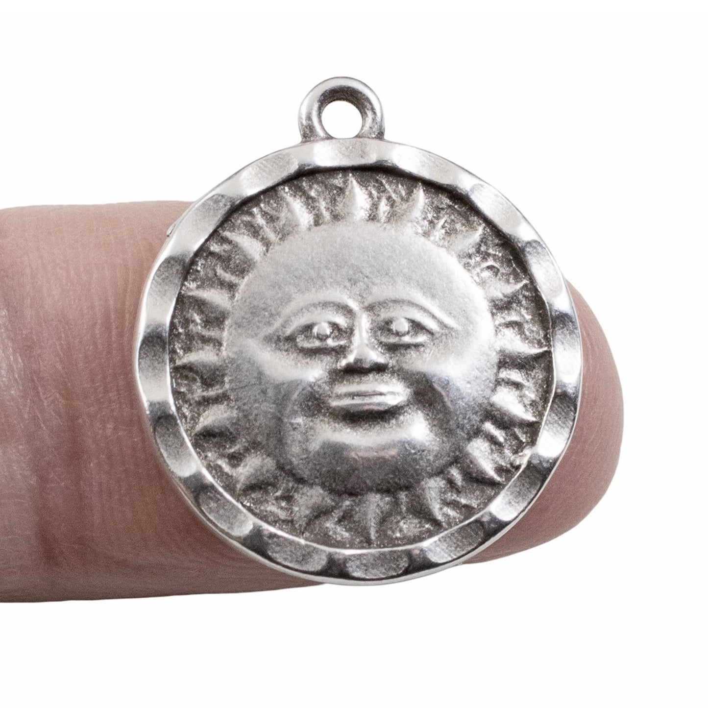 Hackberry Creek antique silver sun face pendant held on a finger showing detailed celestial design
