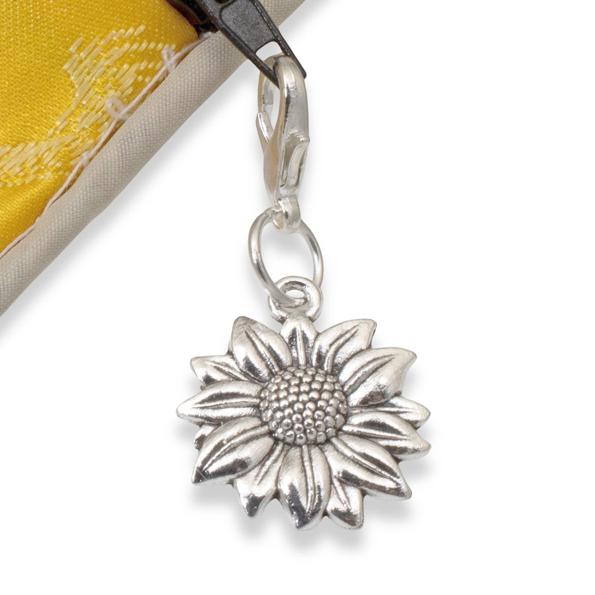 Hackberry Creek silver sunflower clip-on charm attached to a yellow fabric bag zipper