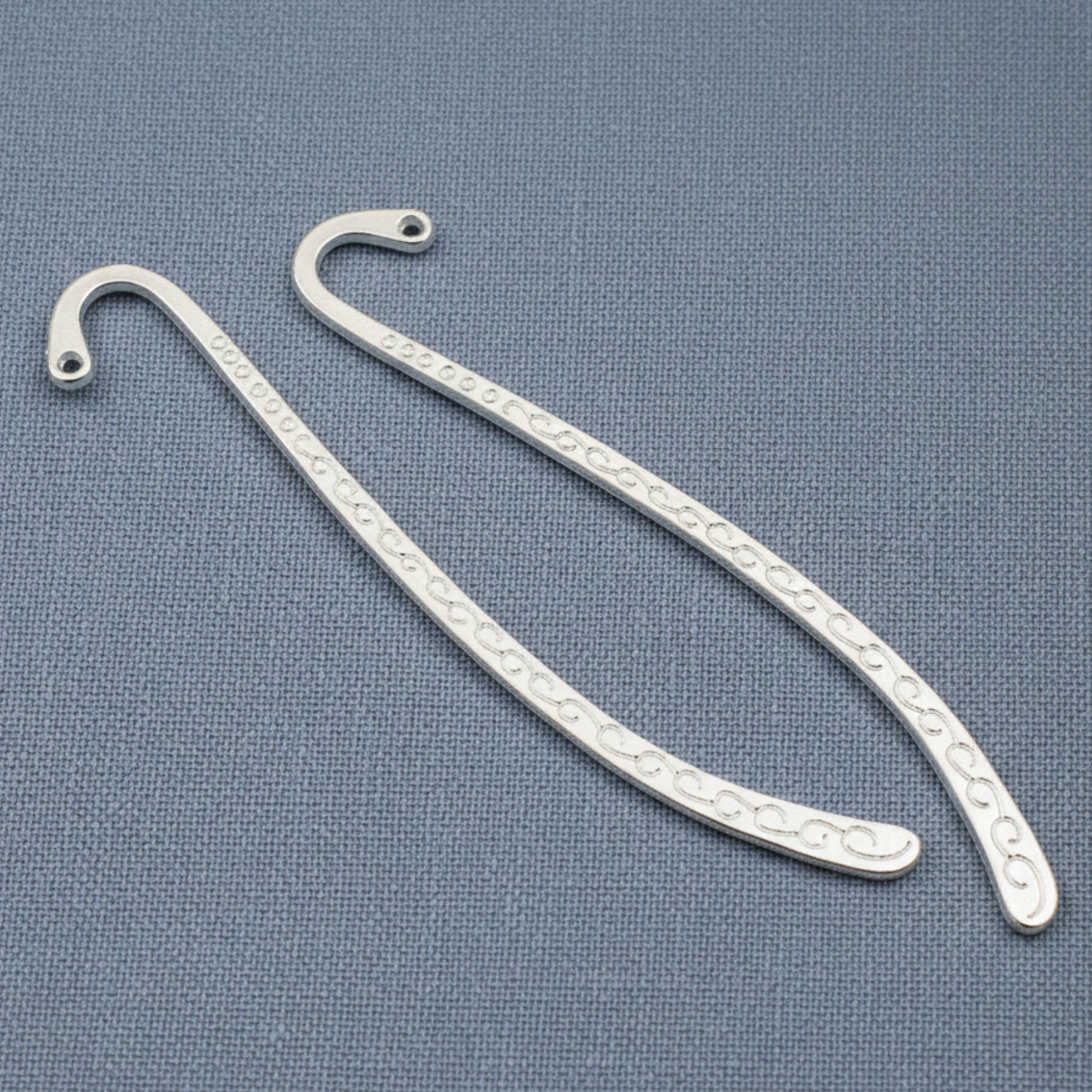 Hackberry Creek silver-tone zinc alloy hook bookmark blanks with decorative swirl patterns for DIY charm projects.