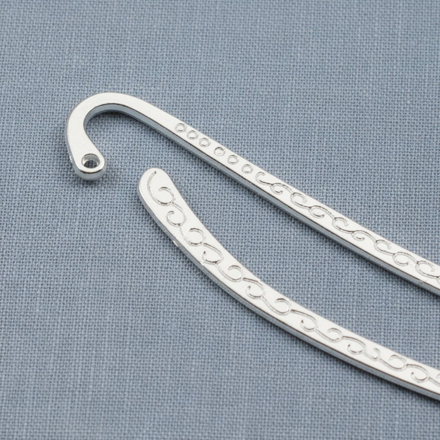 Hackberry Creek silver-tone metal hook bookmark blanks with intricate Tibetan swirl patterns for DIY charm projects.