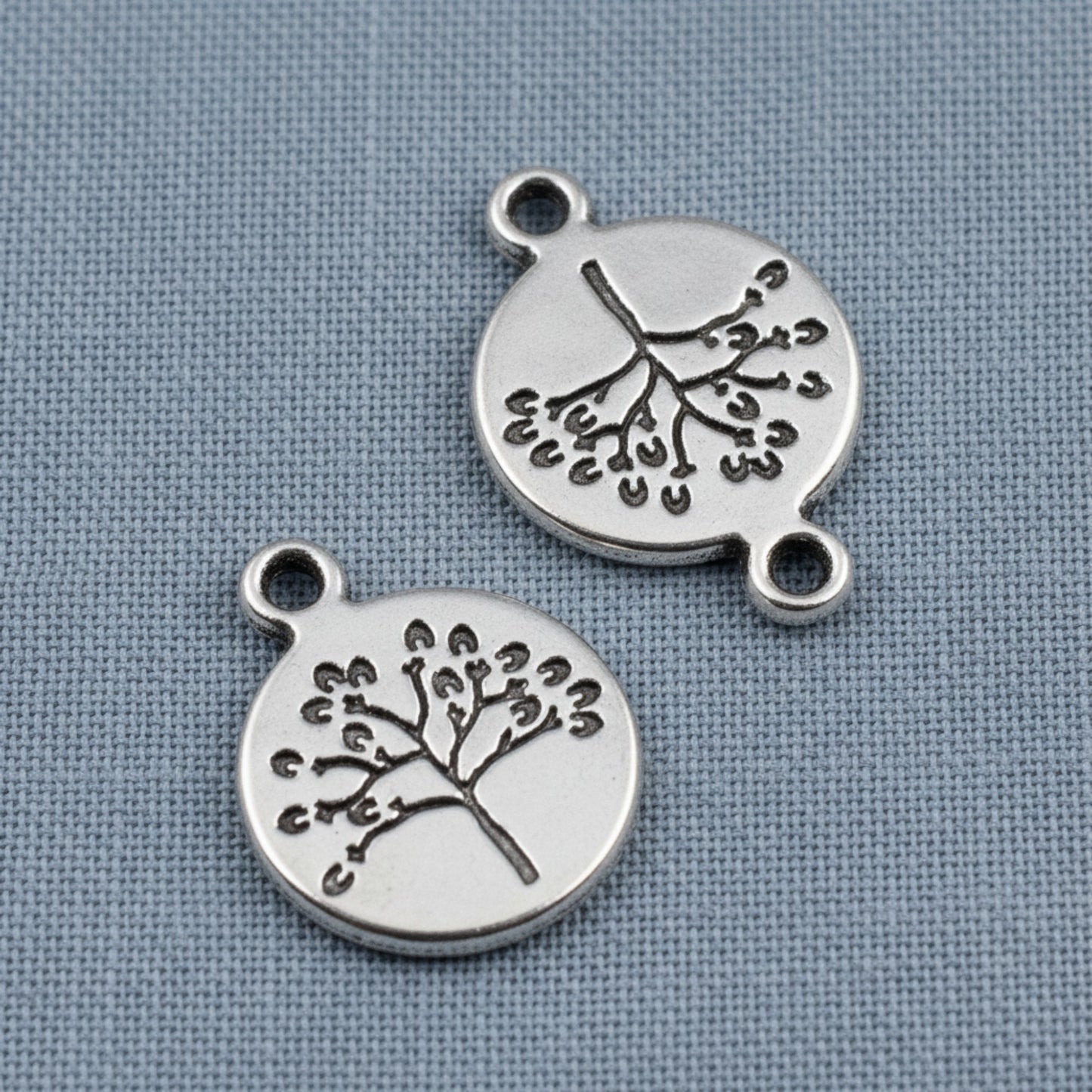 Hackberry Creek antique silver tree of life coin charms with detailed double-sided nature design for jewelry making.