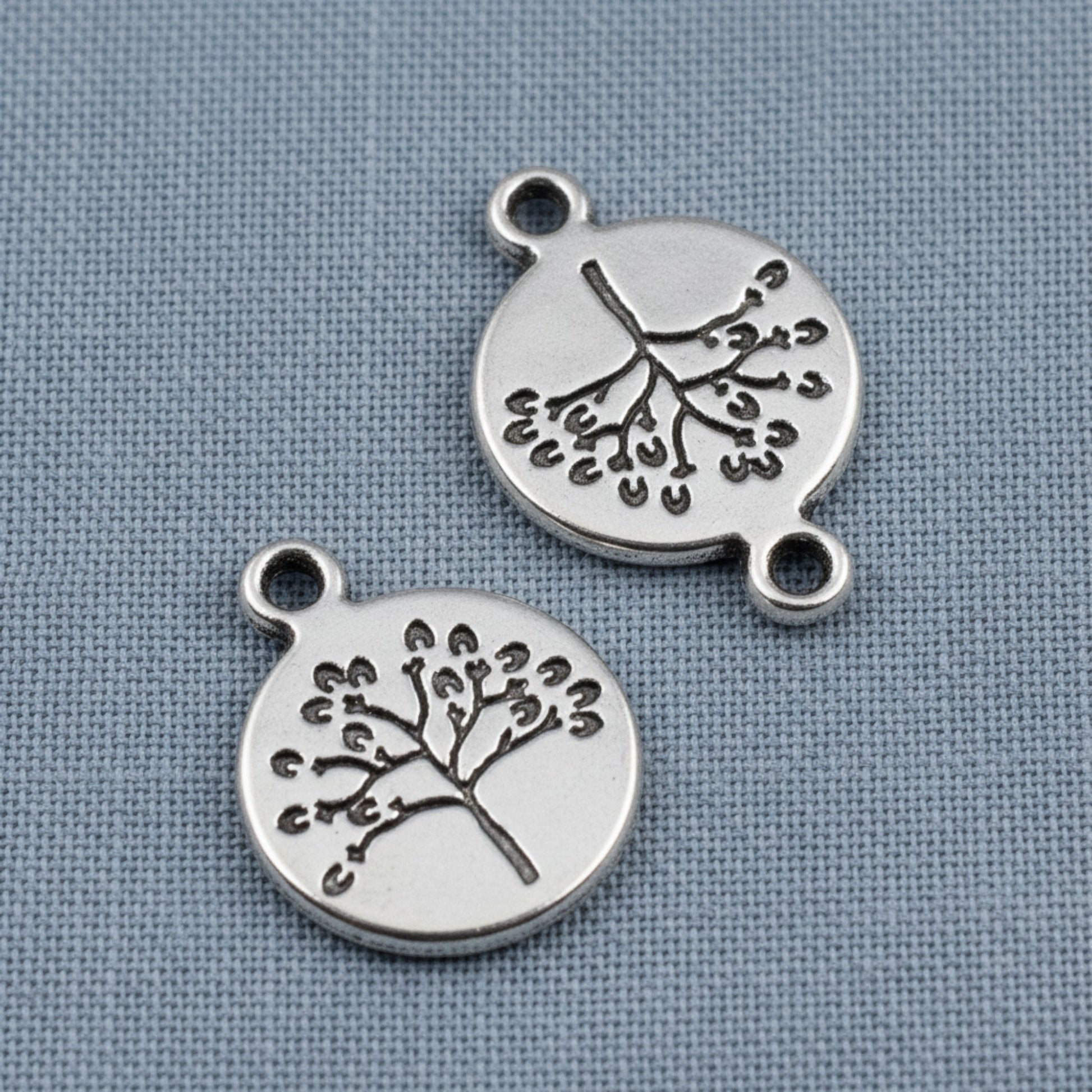 Hackberry Creek antique silver tree of life coin charms with detailed double-sided nature design for jewelry making.