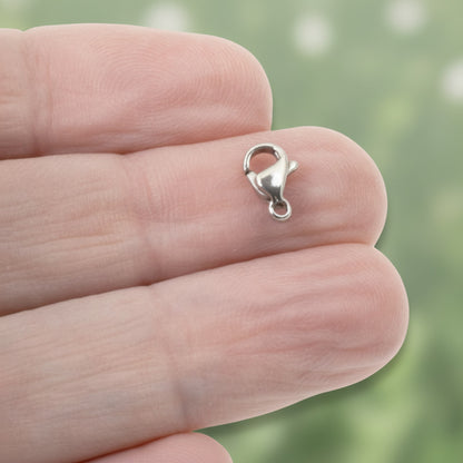 Hackberry Creek tiny dark silver stainless steel lobster claw clasp held between fingers for jewelry making