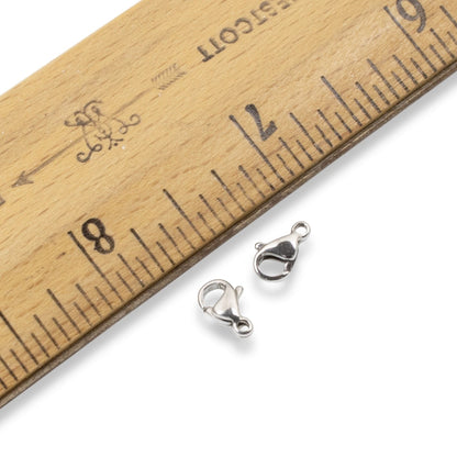 Hackberry Creek 6x9mm dark silver stainless steel lobster claw clasps next to a wooden ruler for scale