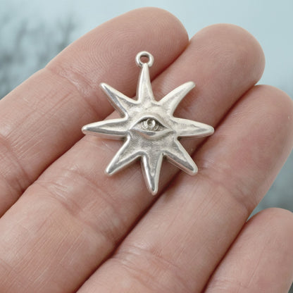 Hackberry Creek sterling silver-plated star eye pendant held in hand, featuring celestial eight-pointed star design.
