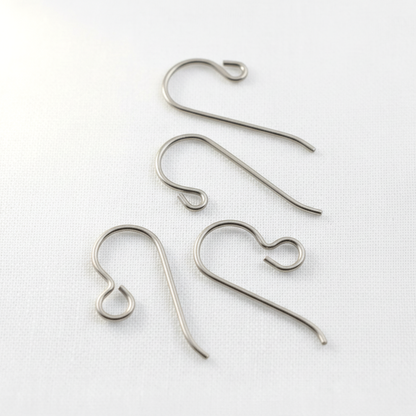 Hackberry Creek hypoallergenic titanium earring hooks in regular and front loop styles on a white fabric background.