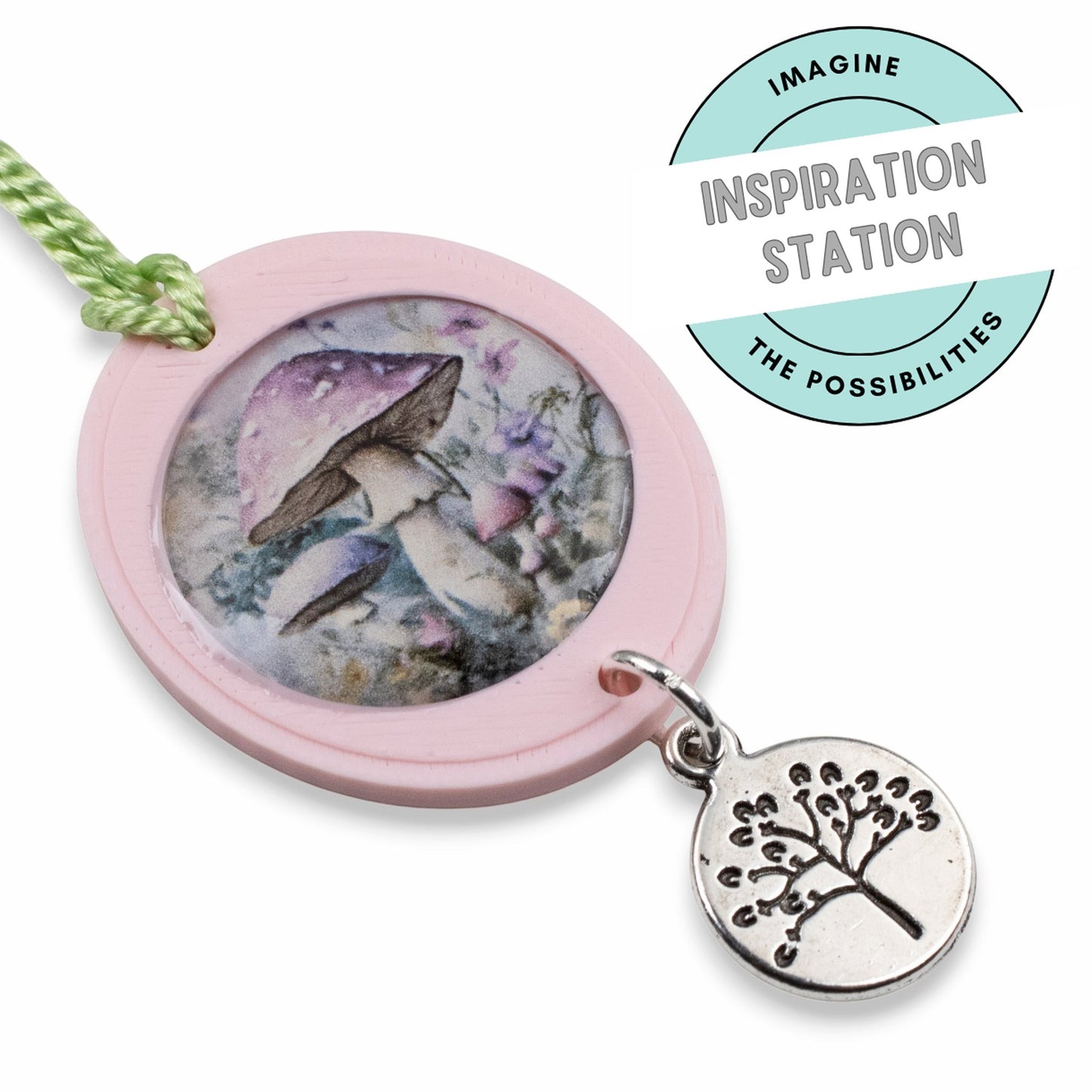 Hackberry Creek antique silver tree of life coin charm attached to a pink mushroom pendant on a green cord