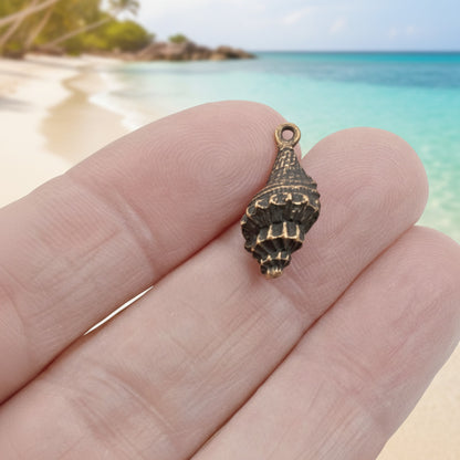Hackberry Creek 21mm antique copper plated pewter trumpet shell charm with intricate spiral detail.