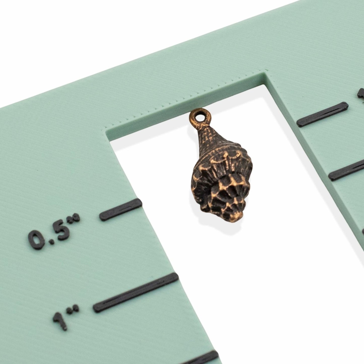 Hackberry Creek 21mm copper-plated pewter trumpet shell charm with intricate detailing and a loop for jewelry making.