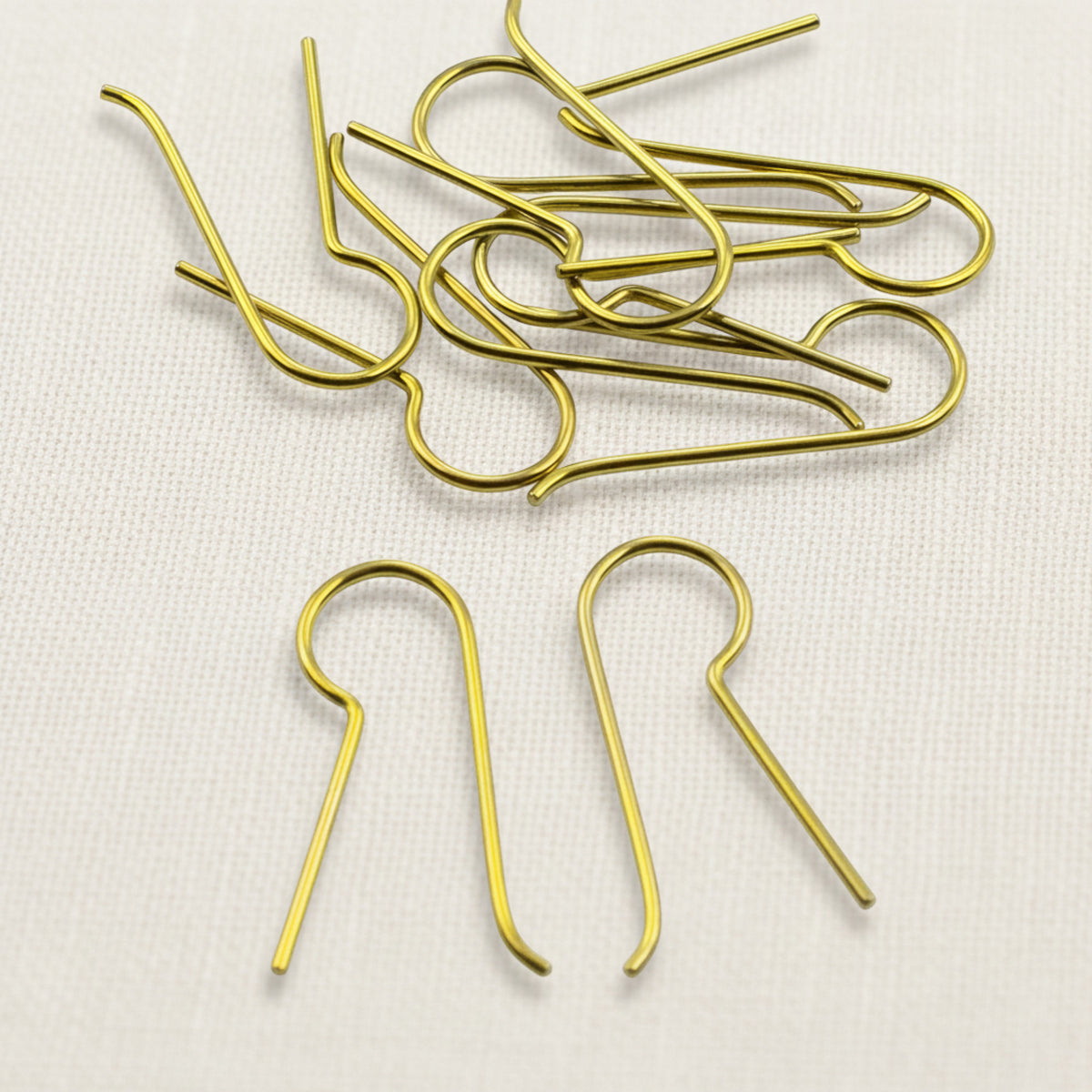 Hackberry Creek yellow niobium earring hooks with a 14mm customizable leg for jewelry making on a white fabric surface.